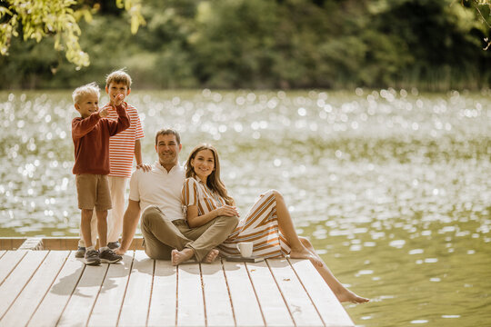 Joyful family enjoying a sunny day by the peaceful lakeside