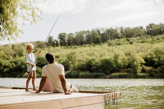 Quality time fishing by the serene lake with father and son in the sunshine
