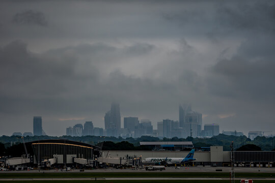 Charlotte skyline beyond airport terminal under overcast sky