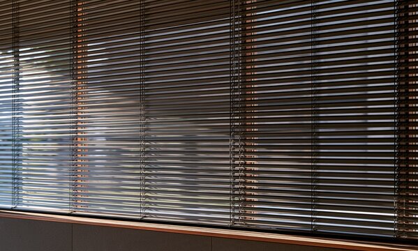Modern office interior window with closed metal louvers filter soft sun