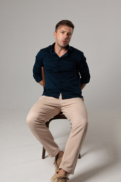 Confident mature man sitting on chair looking forward