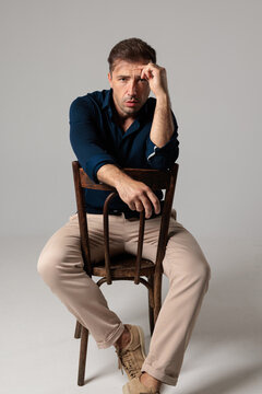 Troubled middle aged man sitting on chair looking forward