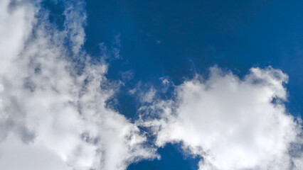 Obraz premium Low angle shot of wispy white clouds against vibrant blue sky during daytime.