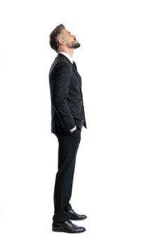 Side view of formal man looking up with hands in pockets