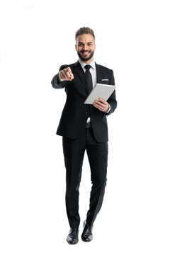 Positive man standing pointing finger and holding tablet