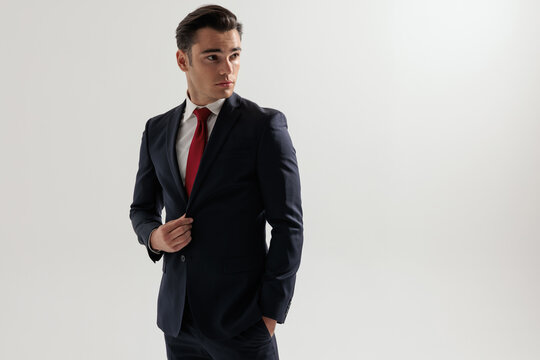 Elegant man adjusting suit and looking to the side