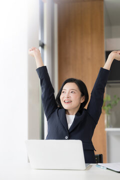 仕事の合間に肩こりのストレッチをする女性会社員、オフィスでリフレッシュするミドル世代のビジネスウーマン 健康経営のイメージ