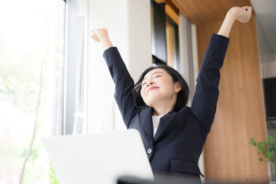 仕事の合間に肩こりのストレッチをする女性会社員、オフィスでリフレッシュするミドル世代のビジネスウーマン 健康経営のイメージ