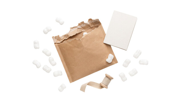 Recycled brown paper envelope with packing peanuts, torn kraft mailer for sustainable shipping, blank white card with ribbon isolated PNG with Transparent Background