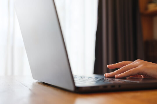 Closeup image of a woman working and touching on laptop computer touchpad