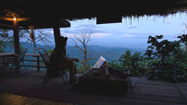 A woman sitting on wooden terrace and looking at nature views