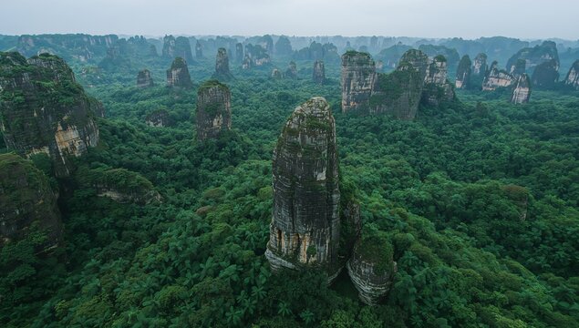 Towering jagged limestone karst pillars rising from emerald green forest