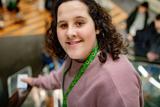 Smiling young woman riding an escalator at the busy public transport station