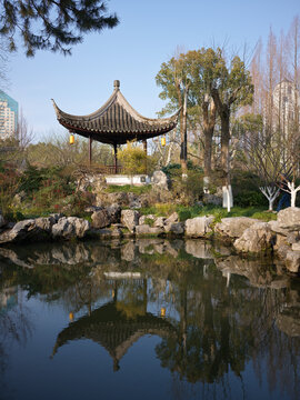 A park lake with a pavilion, tour boat and reflections, China