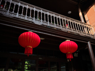 An old gray-brick house with red lanterns under the eaves, China © viabadalona