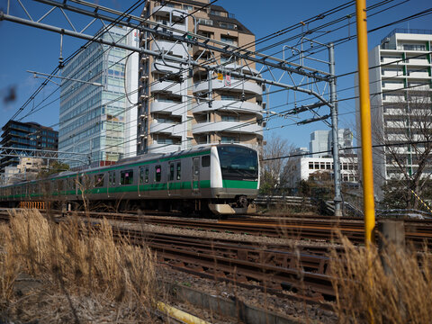 Commuter trains on an elevated railway beside apartment towers, Japan