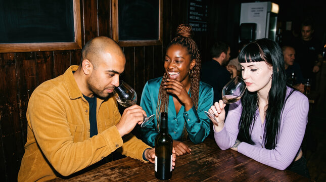 Friends compare wine glasses at a cozy wine bar