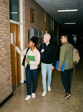 Students looking for a classroom along a corridor