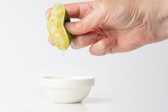 Squeezed lime isolated, squeezed out half green lemon on white background, burnout symbol