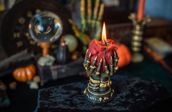 Burning heart candle held by witch hands on magical altar for love spells, cleansing negative energy and romantic rituals 