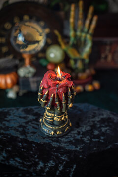 Burning heart candle held by witch hands on magical altar for love spells, cleansing negative energy and romantic rituals 