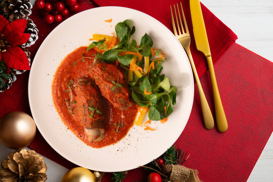 Cheese-stuffed veal roll with tomato sauce. Top-down view. Traditional Christmas recipe.