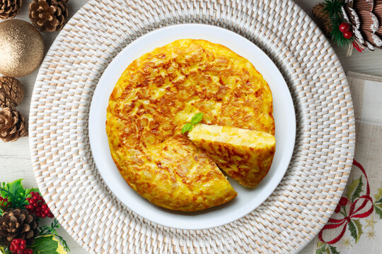 Spanish potato omelet tapa with a slice cut out. Top-down view. Traditional Christmas recipe.