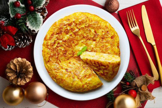 Spanish potato omelet tapa with a slice cut out. Top-down view. Traditional Christmas recipe.