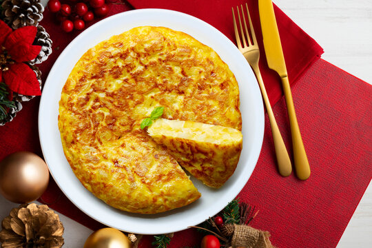 Spanish potato omelet tapa with a slice cut out. Top-down view. Traditional Christmas recipe.