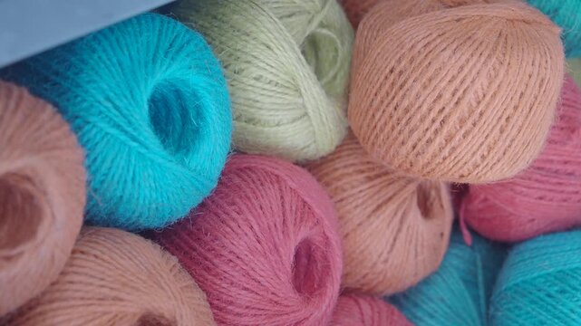 Close up cinematic footage of colorful wool yarn balls stacked in rows for knitting and craft projects