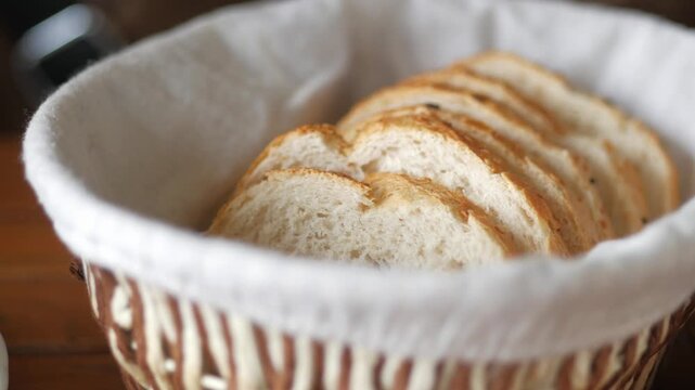 Hand picking slices of fresh bread from basket for meal preparation