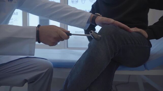 Doctor Testing Patient Knee Reflex with Neurological Reflex Hammer in Medical Clinic