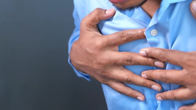 Unrecognized man holding chest in pain suffering from sudden heart attack or severe respiratory problem