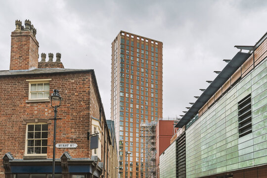 View of a modern skyscraper rising behind historic red brick buildings on Hurst Street in Birmingham, England, United Kingdom.