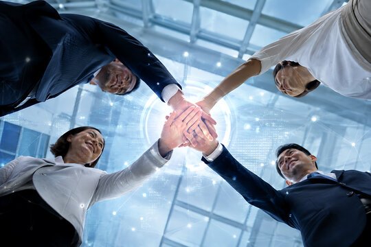 Business team celebrates success with a collaborative handstack in an office setting