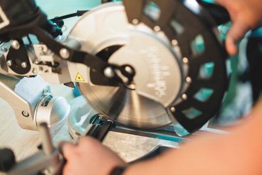 Cutting process using a miter saw in a workshop with focus on precision and craftsmanship