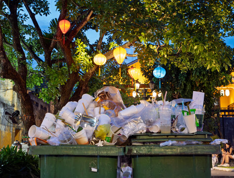 Overflowing waste bins, disposable cups and colorful lanterns in Hoi An, Vietnam