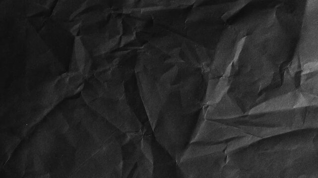 Dark black crumpled paper texture background, with subtle light reflections