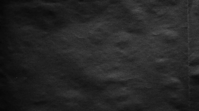 Dark matte black paper texture background, with subtle creases, and grainy surface
