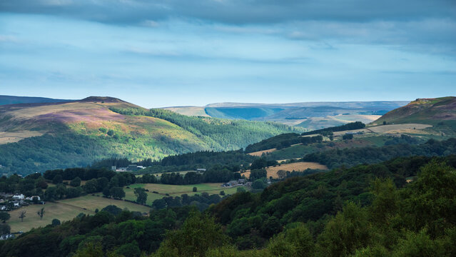 Stunning Peak District landscape from Surprise View with vibrant heather and dappled sunlight over the hills