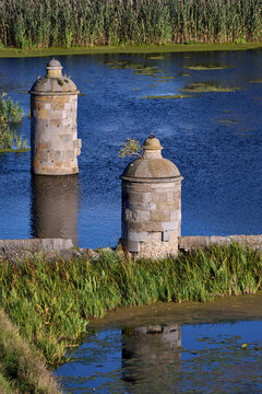 Dragon boat team rowing on the Motlawa River past the historic Kamienna Sluza stone lock towers in Gdansk, Poland