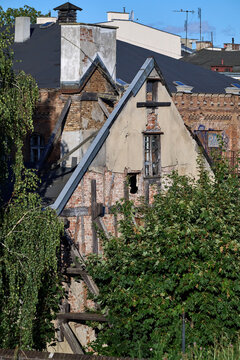 Partially ruined historic timber-framed brick building surrounded by trees in Gdansk, Poland