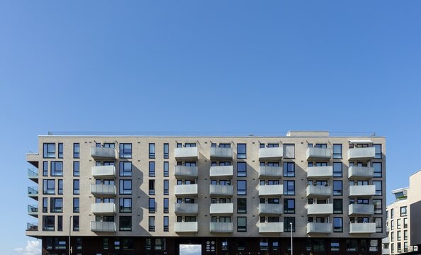 Oslo modern apartment building facade with balconies under blue sky