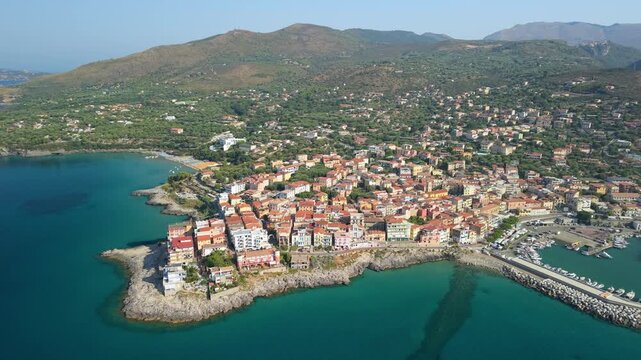 Marina di Camerota Cilento Campania Italy aerial drone panning peninsula marina town white boats turquoise coves beach mountain backdrop morning light travel 4k video