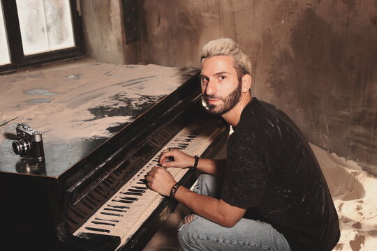 Youthful individual in casual attire playing piano next to vintage camera