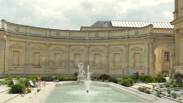 Elegant stone courtyard with fountain and curved facade in Amiens France