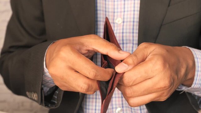 Close up view of man holding empty wallet showing financial loss or poverty concept in studio shot