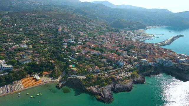 Marina di Camerota Cilento Italy 4K drone video. Golden hour sunrise panning over coastal town with turquoise sea beaches and harbor. Scenic Mediterranean travel b roll stock footage
