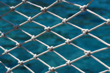 White rope safety net with knots over turquoise sea water © dddoria
