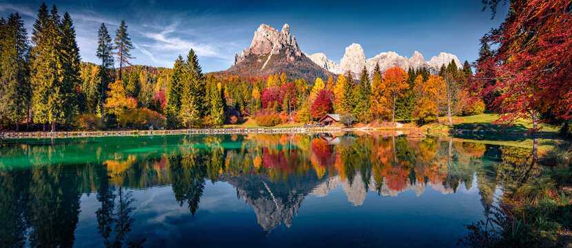 Panoramic autumn view of Welsperg lake. Calm morning scene of Tonadico, Province of Trento, Italy, Europe. Colorful landscape of Dolomite Alps. Beauty of nature concept background.